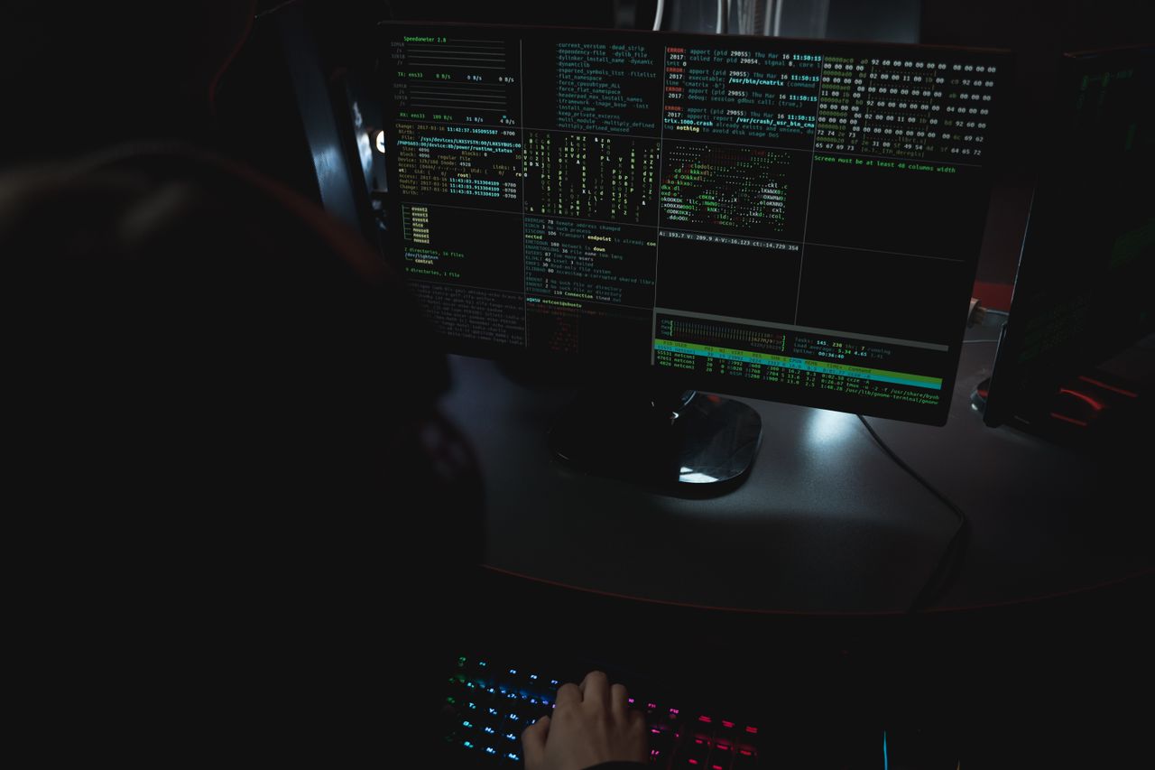 Dual monitors displaying code in a dark room, the working setup of a GTM engineer building outbound systems